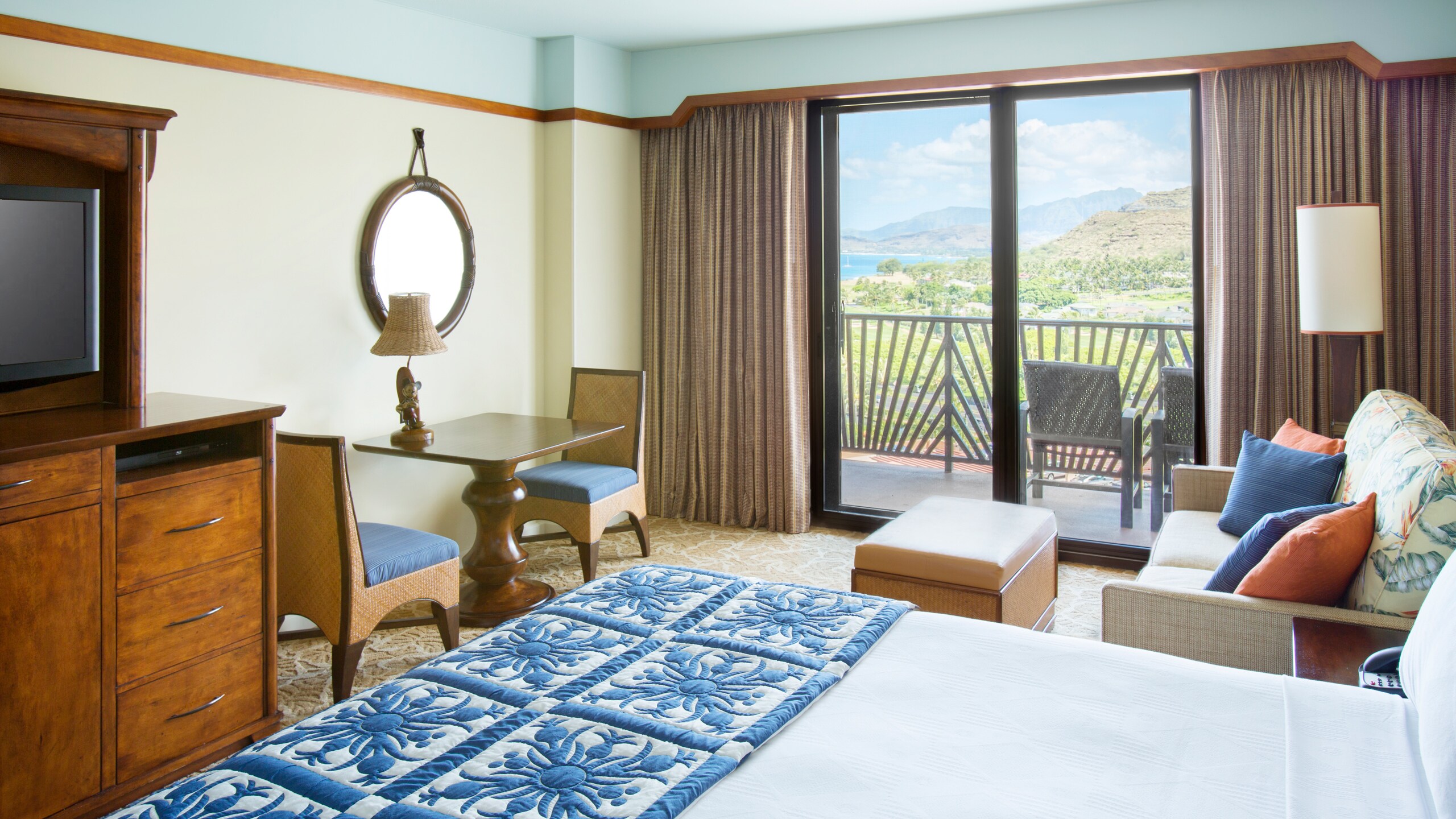 The bed and living area of a Deluxe Studio at Aulani